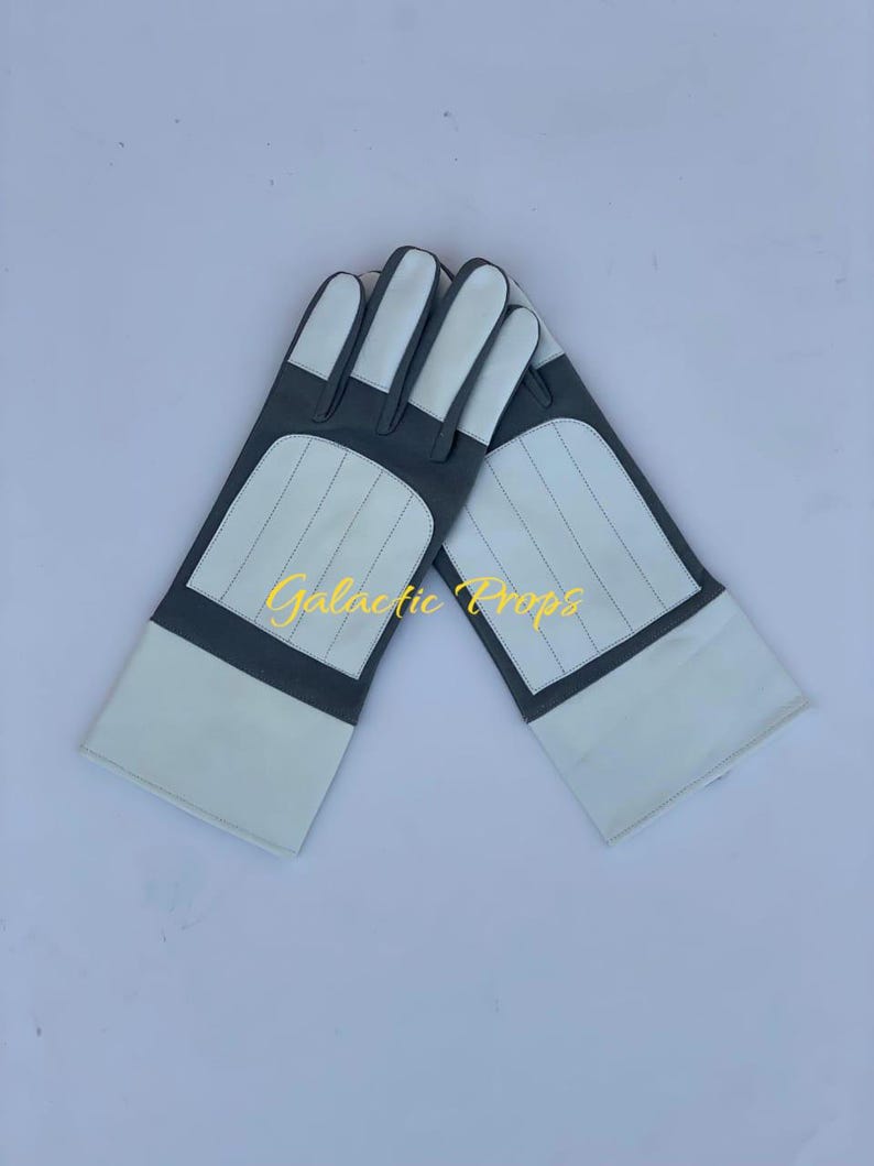 May include: A pair of white and gray gloves with the text "Galactic Props" in yellow. The gloves have white fingertips and cuffs, with gray panels and stitched details.