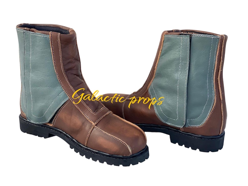 Puede incluir: Un par de botas de cuero marr&oacute;n con un panel de gamuza verde en el lateral. Las botas tienen un cierre de cordones en la parte delantera y un tac&oacute;n grueso.