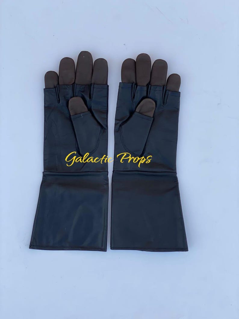 May include: A pair of black gloves with brown fingertips and the text "Galactic Props" in gold lettering. The gloves have long cuffs and are displayed on a light blue background.