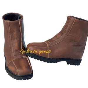 Puede incluir: Un par de botas de cuero marr&oacute;n con una cremallera en el lateral. Las botas tienen una suela gruesa y una punta puntiaguda.