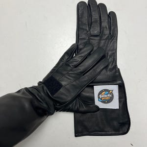 May include: Black leather gloves with extended cuffs. One glove features a Velcro strap at the wrist. A white label with the text "Galactic Props" is attached to the cuff of one glove.