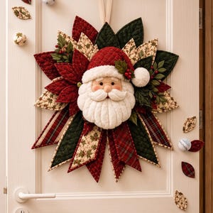Könnte beinhalten: Ein gesteppter Weihnachtskranz aus Stoff mit einem zentralen Weihnachtsmann-Gesicht, weißem Bart und roter Mütze. Der Kranz besteht aus geschichteten, spitz zulaufenden Stoffblütenblättern in Rot, Dunkelgrün und Creme mit Stechpalmen- und Karomustern.