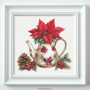 Könnte beinhalten: Kreuzstichbild einer Teekanne, gefüllt mit einem roten Weihnachtsstern-Blumenarrangement. Die Teekanne ist mit floralen Mustern verziert und steht neben einem Tannenzapfen und Zweigen von Grün. Das Kunstwerk ist in einem weißen quadratischen Rahmen gerahmt.