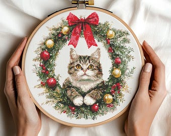 Patrón de punto de cruz de gato en corona navideña (PDF). Descarga digital. Adorable gato en corona festiva con adornos y lazo rojo.