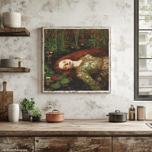 May include: A framed print of a painting depicting a woman with long red hair floating in water among lily pads. The woman wears a green floral dress. The artwork is displayed in a rustic kitchen setting.
