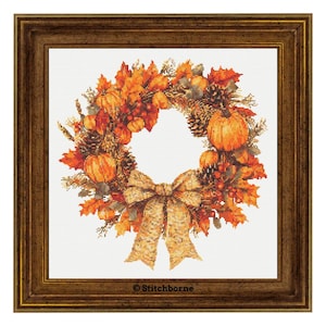 Könnte beinhalten: Ein herbstliches Kranz mit Kürbissen, Blättern und Tannenzapfen, akzentuiert durch eine große Schleife. Der Kranz ist in einem braunen Holzrahmen gesetzt, ideal für die saisonale Heimdekoration. Die Farbpalette umfasst Orange-, Braun- und Goldtöne.