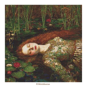 May include: A cross-stitch pattern depicting a woman with long red hair floating in water, surrounded by lily pads and reeds. She wears a green floral dress. The image has a painterly quality and is based on a famous painting.