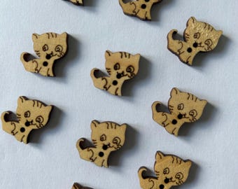 May include: Ten wooden buttons shaped like cats with brown painted details. The buttons have two holes for sewing.