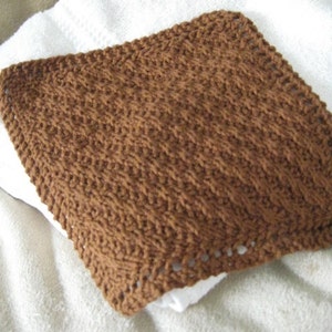 以下が含まれることがあります： 茶色の編み地の食器用ふきん。ざらざらした模様が施されています。ふきんはシンプルな編み方で、縁が少しほつれています。