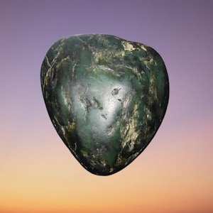 May include: A polished, heart-shaped stone featuring a deep forest green colour with mottled dark veins and lighter, cream-coloured inclusions throughout its smooth, rounded surface. The object has a natural, irregular texture with visible surface variations.