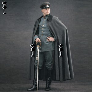 Puede incluir: Un uniforme militar con una capa gris, un sombrero a juego y una chaqueta azul claro con botones dorados. El uniforme incluye pantalones oscuros, botas altas negras y una espada. El atuendo es de estilo militar histórico.