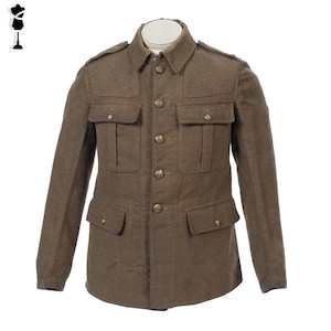 May include: A brown military jacket with four front pockets and gold-colored buttons. The jacket has a collared neckline and epaulettes on the shoulders. The jacket is displayed on a white mannequin.