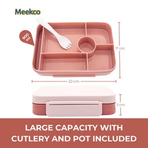 May include: A pink divided lunch box with a white fork, measuring 22 cm long, 17 cm wide, and 5 cm high. The lunch box has a capacity of 900 ml and includes a pot and cutlery. The text "LARGE CAPACITY WITH CUTLERY AND POT INCLUDED" is displayed.