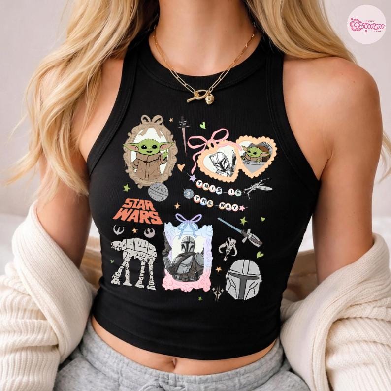 May include: Black tank top featuring Star Wars graphics, including Grogu, the Mandalorian, and AT-AT walker. The design incorporates frames, bows, and text elements. The top is sleeveless and has a round neckline.