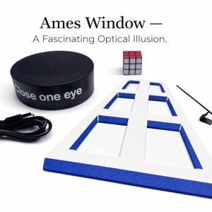May include: Ames Window optical illusion kit. Includes a black cylinder with "Close one eye" text, a Rubik's Cube, a window-shaped frame with blue trim, a black cable, and a black rod with a small black square.