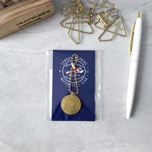 May include: A circular brass-colored metal charm attached to a gold-toned ball chain, presented on a dark blue rectangular card featuring the text Sunday Morning Ace Classics Motorcycle Club and a tiger graphic, packaged in a clear plastic sleeve.
