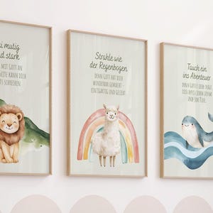 Könnte beinhalten: Drei gerahmte Aquarelldrucke mit inspirierenden Zitaten und Tierillustrationen. Einer zeigt einen Löwen, ein anderer ein Lama mit einem Regenbogen und der dritte einen Delfin. Die Drucke werden über einem Holzbettchen mit einem Teddybären angezeigt.