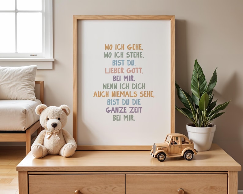 May include: A framed print with the text "WO ICH GEHE, WO ICH STEHE, BIST DU, LIEBER GOTT, BEI MIR." in various colors. A teddy bear, a wooden toy car, and a potted plant sit on a wooden dresser.