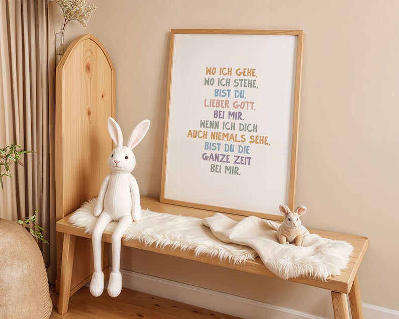 May include: A wooden bench with a white faux fur throw and two stuffed rabbits. A framed print with German text hangs above the bench. The text is in various colors. The room has a neutral color palette.