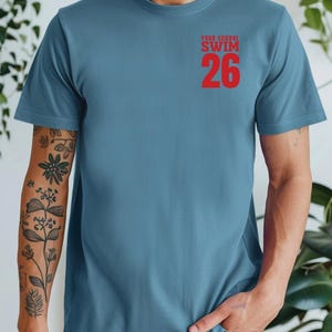 Example of Design on front of tee, Red Text on Slate Blue. Add custom school or mascot name on top line.