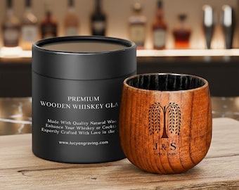 May include: A wooden whiskey glass with a black interior and a matching black box. The glass has a tree design with the initials "J & S" and "SINCE 2011". The box reads "PREMIUM WOODEN WHISKEY GLASS".