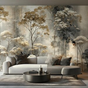 May include: A modern living room featuring a light gray sofa with several decorative pillows, a round dark coffee table, and a matching ottoman. The backdrop is a large mural depicting a stylized forest scene in muted tones.