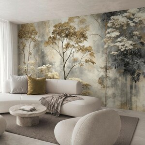 May include: A modern living room with a neutral color palette. A white sectional sofa with throw pillows and a blanket sits in front of a nature-themed mural. A round coffee table and a curved armchair complete the space.