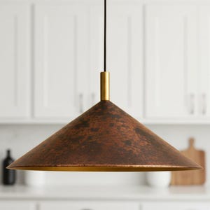 May include: A bronze pendant light with a conical shade and a gold rim. The light hangs from a black cord and a gold cylindrical support. The shade has a textured, mottled appearance. The light is suitable for a kitchen or dining room.