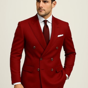 May include: A smart double-breasted red suit, paired with a matching tie and a crisp white shirt. The suit features a classic design with a pocket square. The suit is made of a solid red fabric and is tailored for a formal occasion.