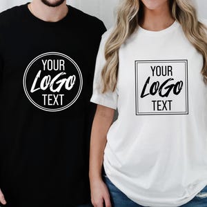 May include: Black and white t-shirts with the text "YOUR LOGO TEXT". The black shirt has a circular design, while the white shirt has a square design. Both shirts are short-sleeved.