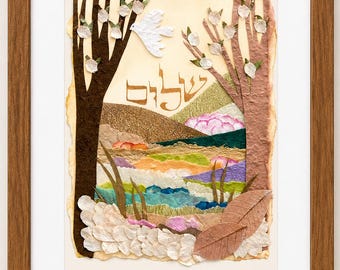May include: A framed mixed-media collage featuring a landscape with two textured trees, a white dove, and the Hebrew word Shalom in gold lettering. The scene includes layered paper elements in shades of brown, green, blue, and pink, with dried leaves and petals.
