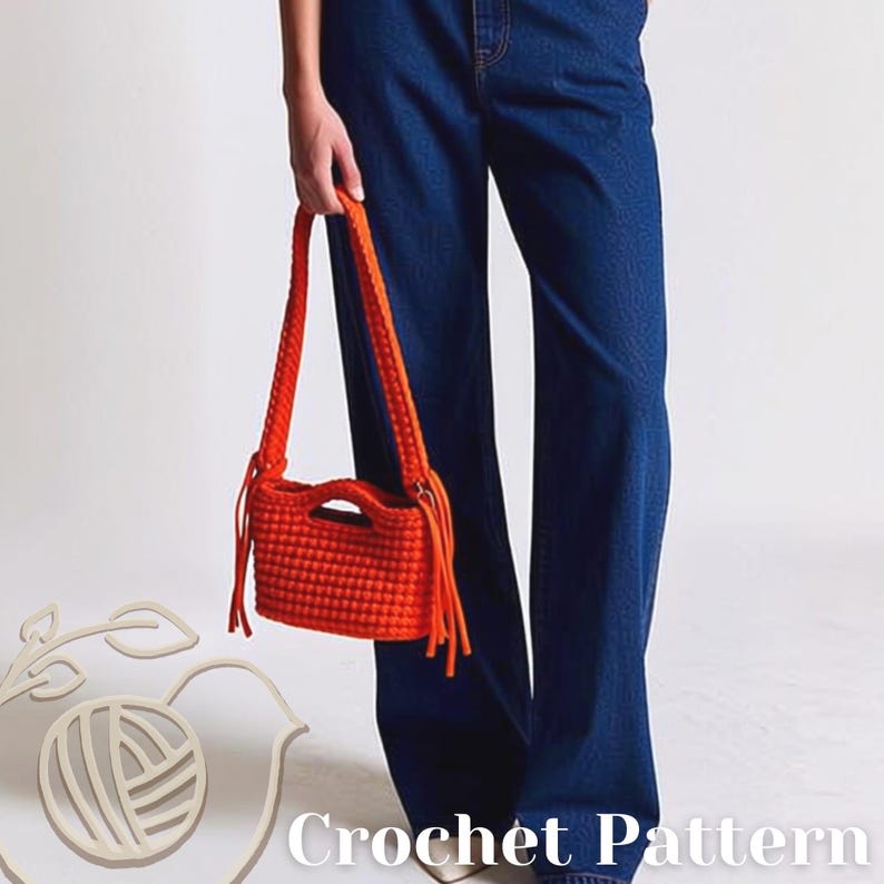 May include: A bright orange crochet handbag featuring a textured bobble stitch pattern, a rectangular body with a cutout handle, and long fringe accents on both sides. The bag is paired with dark blue denim jeans. The text Crochet Pattern is visible.