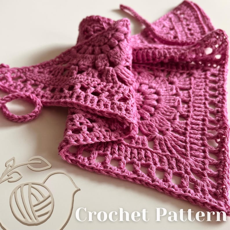 Puede incluir: Un chal de ganchillo rosa con un delicado patr&oacute;n floral. El chal est&aacute; doblado por la mitad y tiene un borde de flecos. La imagen incluye el texto "Crochet Pattern".