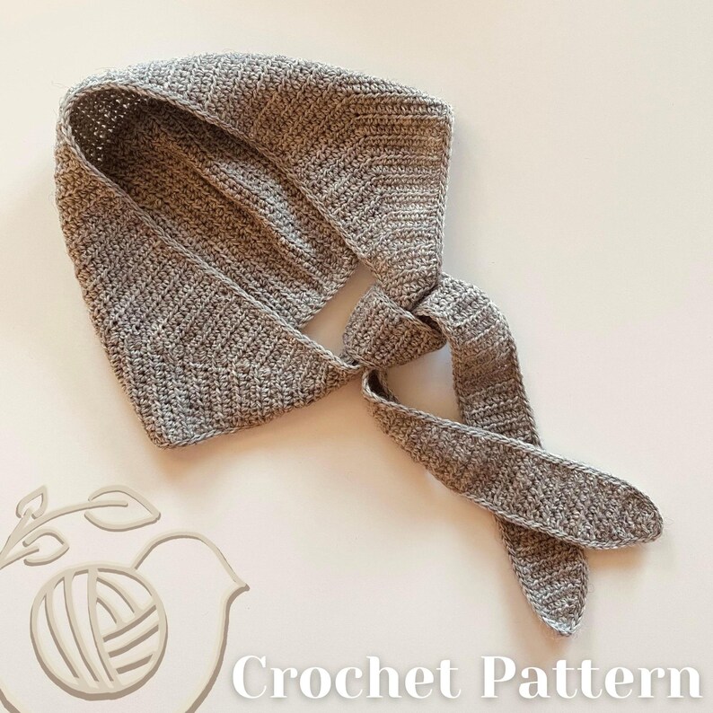 May include: A grey crocheted head covering with long ties, knotted at the base of the neck. The image includes the text "Crochet Pattern". The head covering is made of textured yarn.