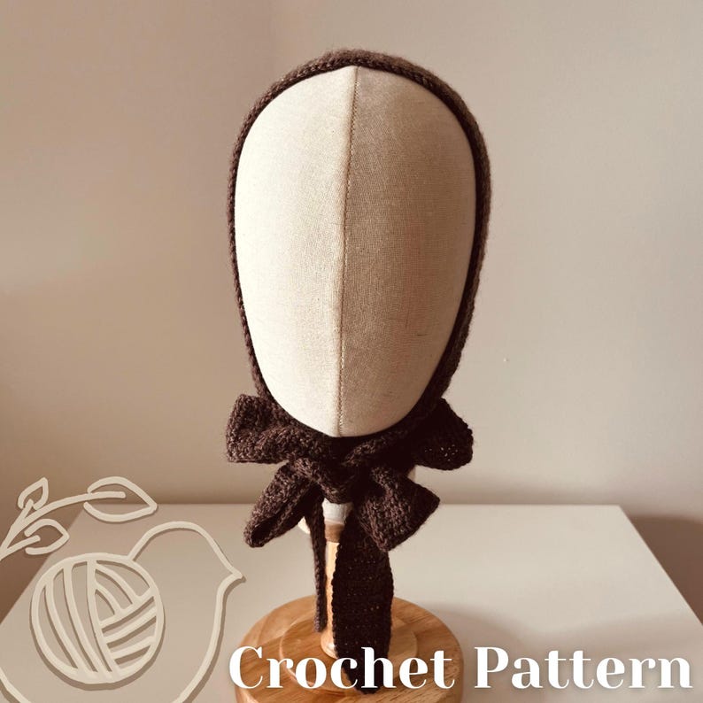 May include: A dark brown crocheted bonnet with a bow detail, displayed on a mannequin head. The bonnet is made of a textured yarn and has a rounded shape. The text "Crochet Pattern" is visible at the bottom of the image.