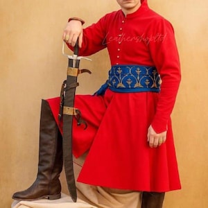 May include: A bright red long-sleeved coat with a high collar and gold buttons, paired with a wide blue sash featuring gold embroidery. The outfit includes dark brown leather boots and a long sword in a black scabbard with gold metal accents.