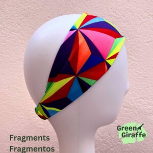 May include: A colorful headband with a geometric pattern in shades of red, pink, blue, orange, and yellow. The headband is displayed on a white mannequin head. The text "Fragments Fragmentos" is at the bottom left, and "Green Giraffe" is at the bottom right.