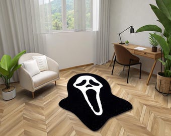 May include: A black and white rug with a ghost face design. The rug is in a living room setting with a chair and a desk.