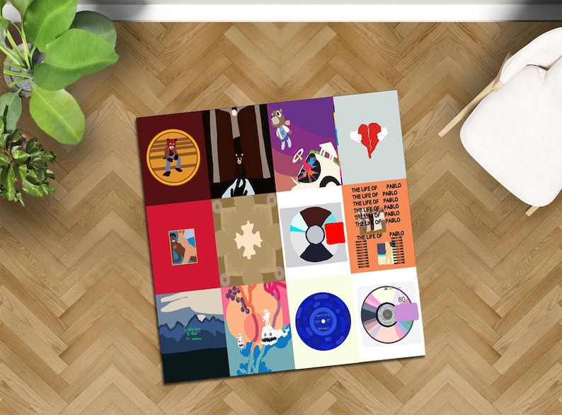 May include: A square art print featuring a collage of album covers and designs. The artwork includes various colors and graphics, including a bear, a broken heart, and the text "THE LIFE OF PABLO". The print is displayed on a wooden floor.