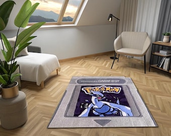 May include: A rectangular rug featuring a Nintendo Game Boy cartridge design with the Pokémon logo and a Lugia graphic. The rug is gray with a purple and blue image, placed on a wooden floor in a room with a window.