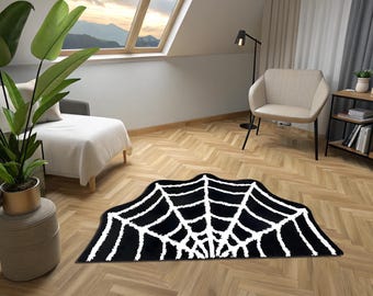 May include: A black and white area rug with a spiderweb design. The rug is shaped like a spiderweb and has a fluffy texture.