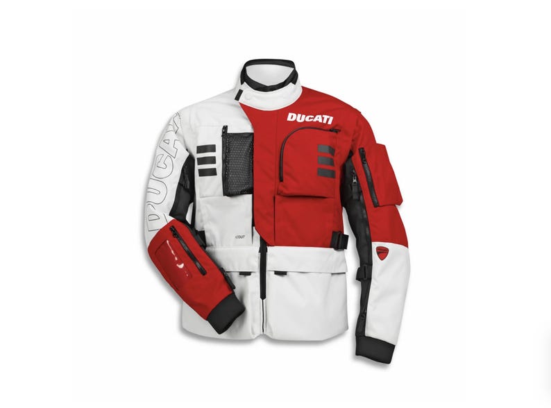 Puede incluir: Chaqueta de moto Ducati blanca, roja y negra. La chaqueta tiene m&uacute;ltiples bolsillos, el logotipo de Ducati y detalles en negro. Las mangas son rojas con pu&ntilde;os negros. Tiene un cuello alto y cierre de cremallera.