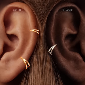 Puede incluir: Dos pendientes tipo ear cuff se muestran en orejas. La oreja izquierda tiene dos ear cuffs dorados de doble banda, etiquetados como GOLD. La oreja derecha tiene dos ear cuffs plateados de doble banda, etiquetados como SILVER.