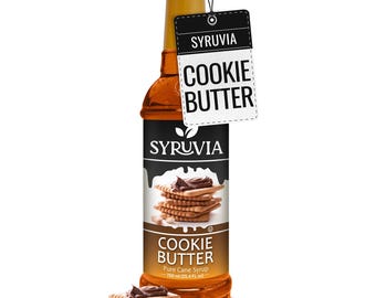 May include: A clear glass bottle of Syruvia Cookie Butter pure cane syrup, 750 ml (25.4 fl oz), featuring a black and white label with a stack of square cookies topped with brown spread, and a hanging tag labeled Cookie Butter.