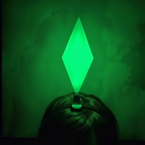 Pode incluir: Uma caneca de cerâmica branca com uma alça preta e o texto "But First, Coffee" em negrito preto. A caneca está sobre um fundo desfocado, sugerindo um ambiente acolhedor.