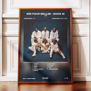 Puede incluir: Un póster enmarcado con la portada del álbum "NÉS POUR BRILLER: BOOK III" de L2B. La imagen muestra a un grupo de personas vestidas de blanco. El póster incluye el título del álbum, la lista de canciones y la fecha de lanzamiento.