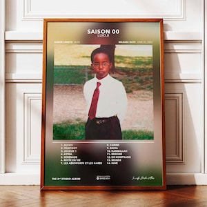 May include: Album cover art for the album "Saison 00" by LUIDJI. The cover features a young boy wearing a white shirt and a red tie, standing in front of a green grassy area. The album title and release date are printed on the cover.