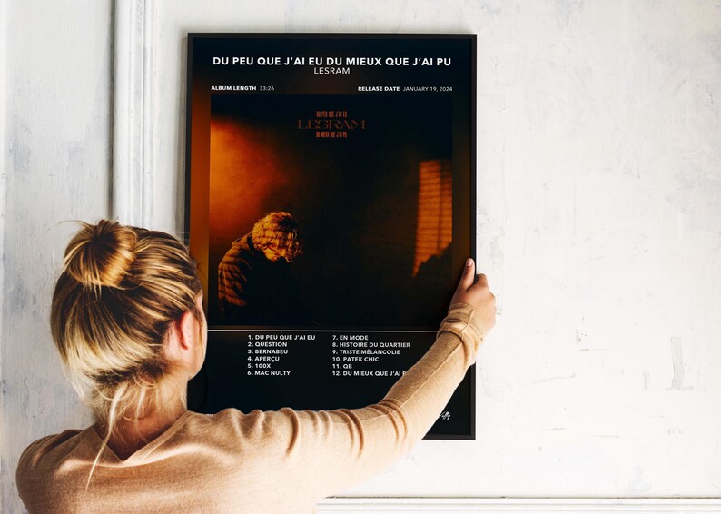 May include: A black framed poster with the text "DU PEU QUE J'AI EU DU MIEUX QUE J'AI PU" and "LESRAM". The poster features a dark image of a person and a list of song titles. Album length is 23-26.