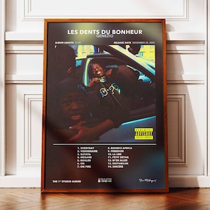 Può includere: Un poster incorniciato per l'album "Les Dents Du Bonheur" di Genezio. Il poster presenta una fotografia di persone in un'auto. Sono visualizzati anche la tracklist dell'album e la data di uscita. Il poster è in una cornice di legno.