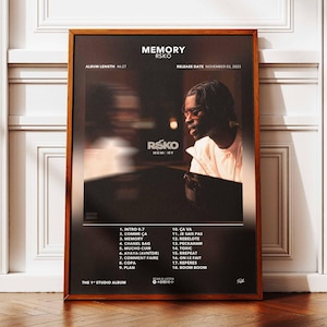 Può includere: Un poster incorniciato con il titolo dell'album "MEMORY" di RSKO su sfondo scuro. Il poster include la durata dell'album, la data di uscita e una tracklist. Un ritratto di una persona è visibile sul lato destro.
